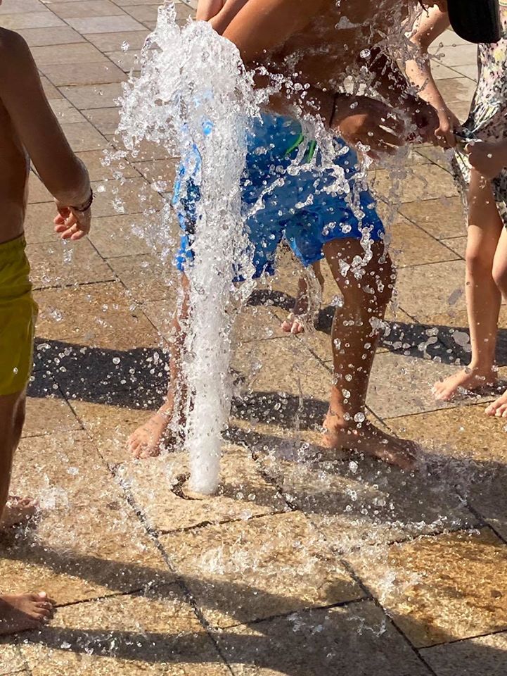 Kinder spielen am Brunnen
